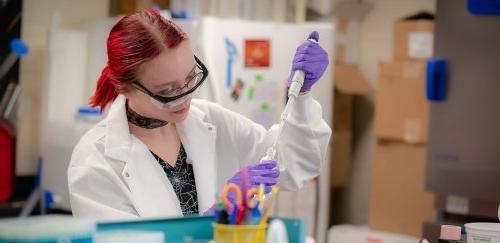 女性在科学实验室将液体注入容器