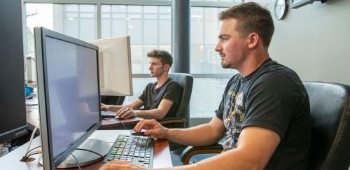 Two students working at computers in Finance Lab